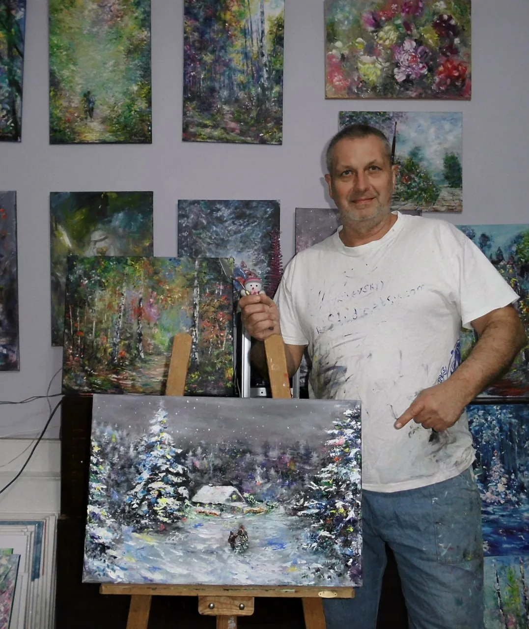 The artist in his studio beside a freshly painted winter landscape, the kind of work commissioned by collectors